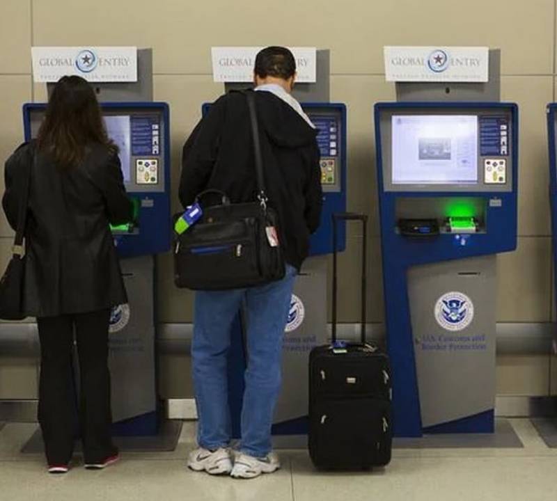 Travelers using Global Entry kiosks at the airport