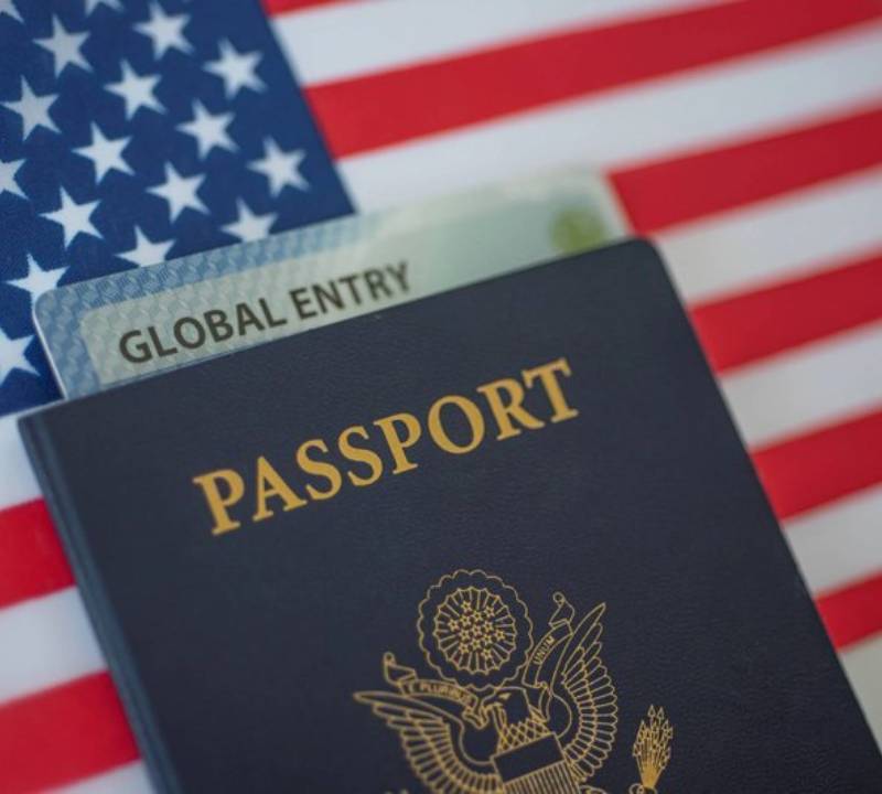 Global Entry card and passport with American flag background